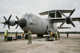 Techniciens militaires effectuant la maintenance d'un avion C-130 Hercules modernisé sur le tarmac d'une base aérienne militaire