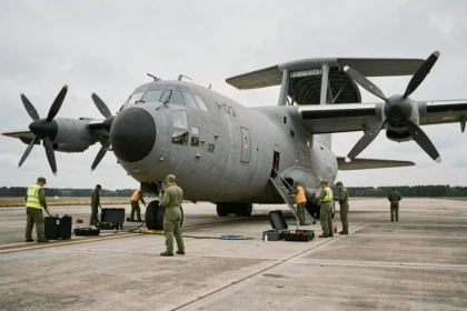 Techniciens militaires effectuant la maintenance d'un avion C-130 Hercules modernisé sur le tarmac d'une base aérienne militaire